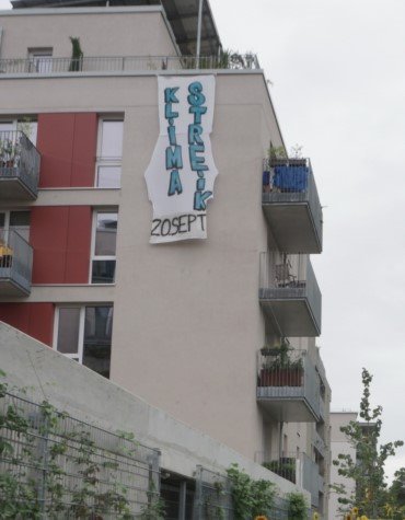 Foto: Spruchband zu Klimaschut an einem Gebäude des Möckernkiezes