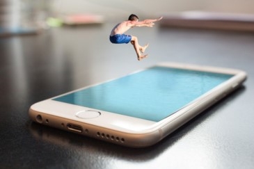 Fotomontage: Mann springt auf ein Smartphone